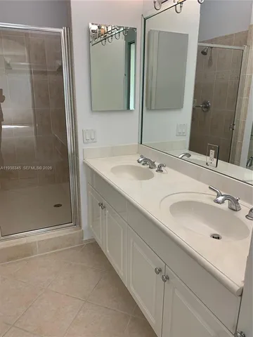 a bathroom with a granite countertop sink and white cabinet
