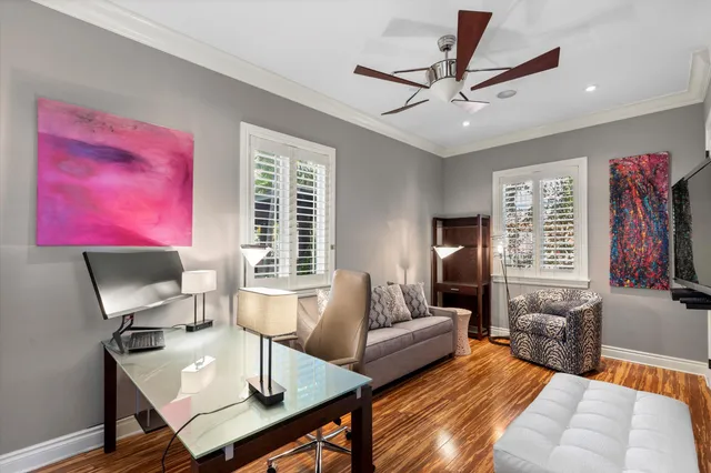 a bedroom with a large bed and a chandelier fan