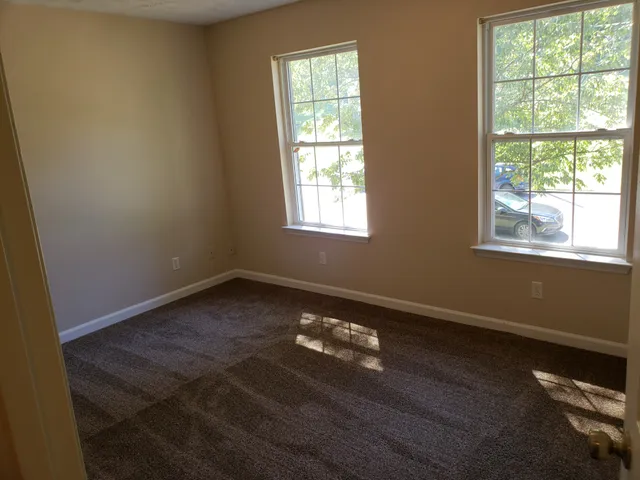 a big room with wooden floor and windows
