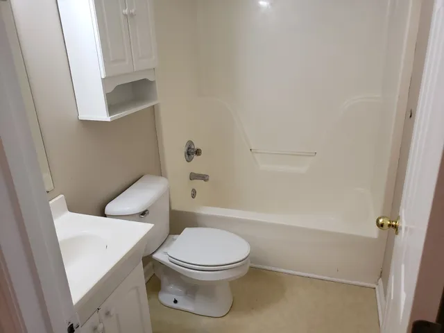 a white toilet sitting next to a bath tub