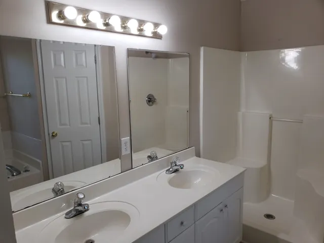 a bathroom with double sink and a mirror