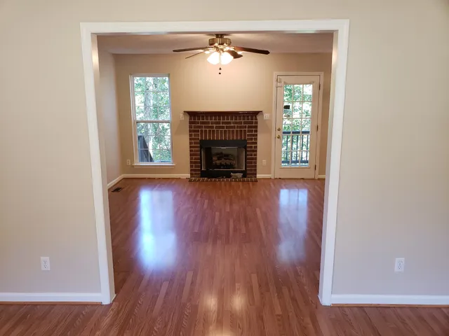 wooden floor fireplace and windows in an empty room