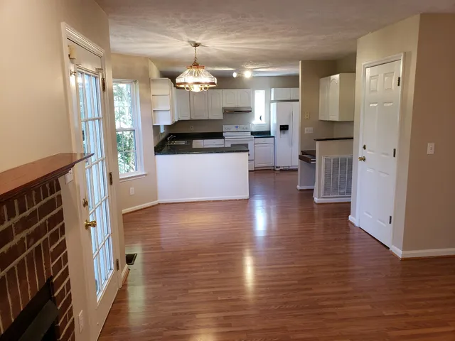 a view of a kitchen with a sink a refrigerator and wooden floor