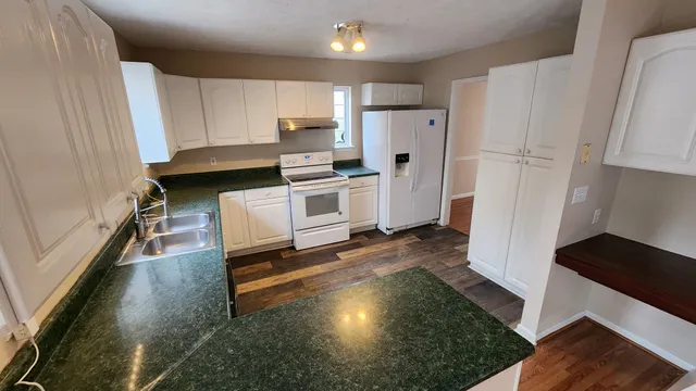 a kitchen with white cabinets and white appliances