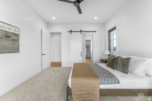 1468 South Red Cliffs Temple Lane St. George, UT 84790 - Photo 32 of 64 Bedroom with a barn door, a walk in closet, carpet floors, ceiling fan, and recessed lighting