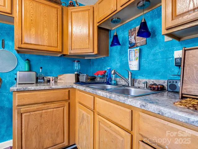 a kitchen with stainless steel appliances granite countertop a sink a stove and cabinets