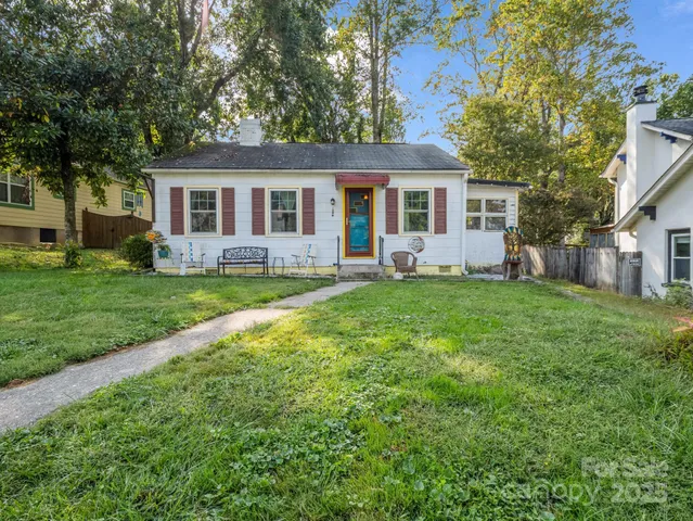 a front view of a house with a yard and trees