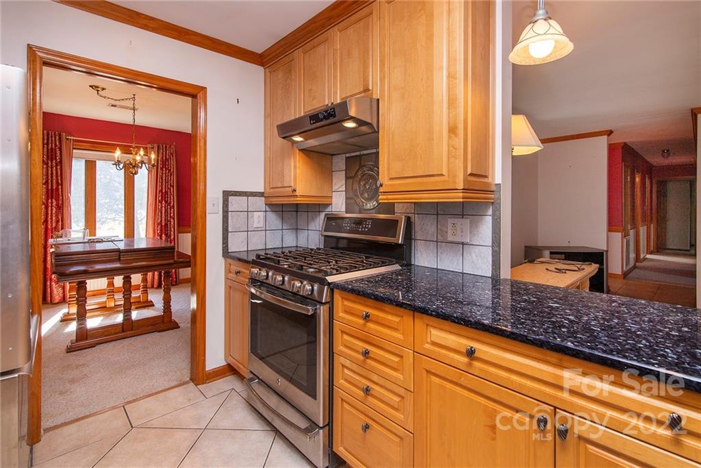 11902 5 Cedars Road Charlotte, NC 28226 - Photo 10 of 24 a kitchen with granite countertop a stove a sink and a microwave