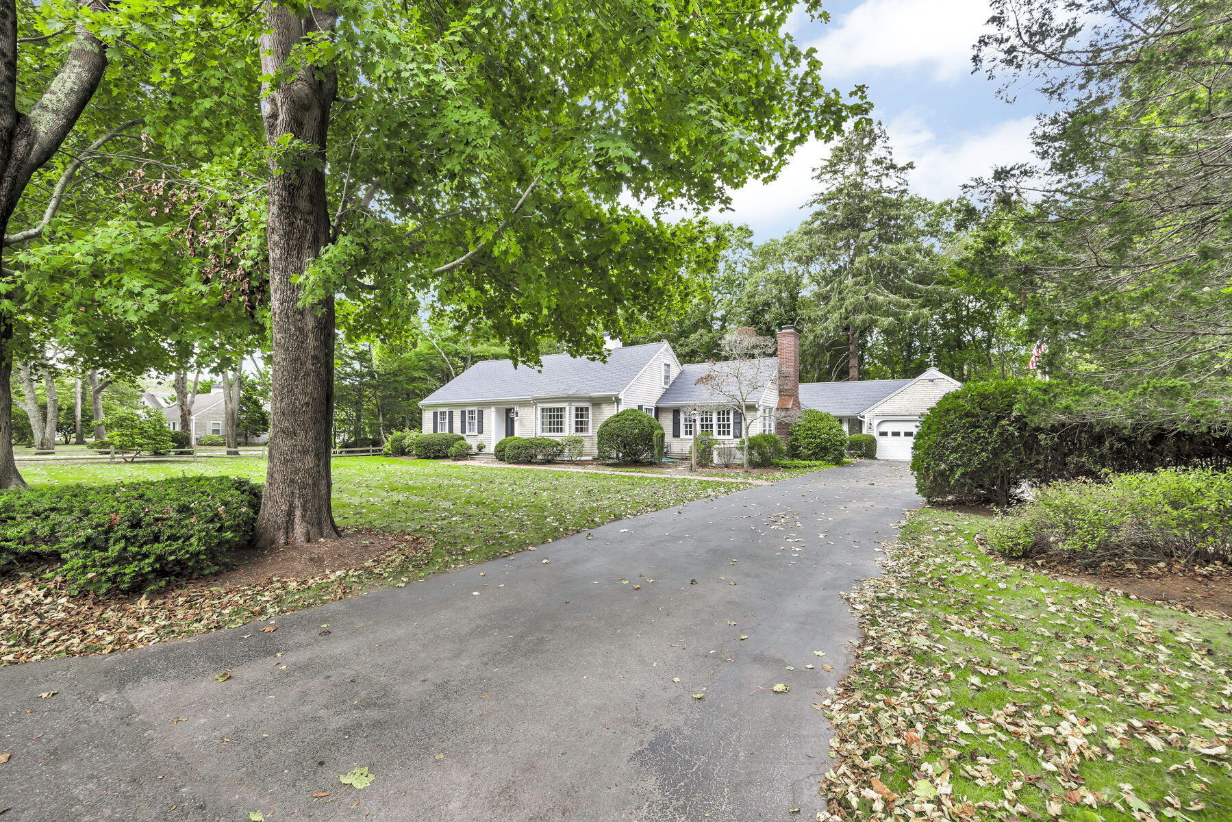 a view of a house with a yard and large trees