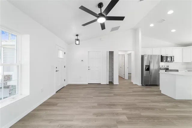 a view of a kitchen with refrigerator and a ceiling fan