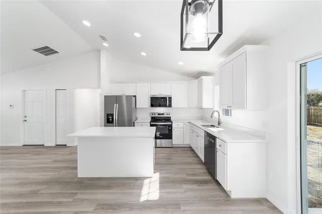 a kitchen with white cabinets and stainless steel appliances