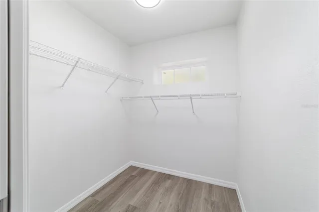 a view of empty room with wooden floor and ceiling fan