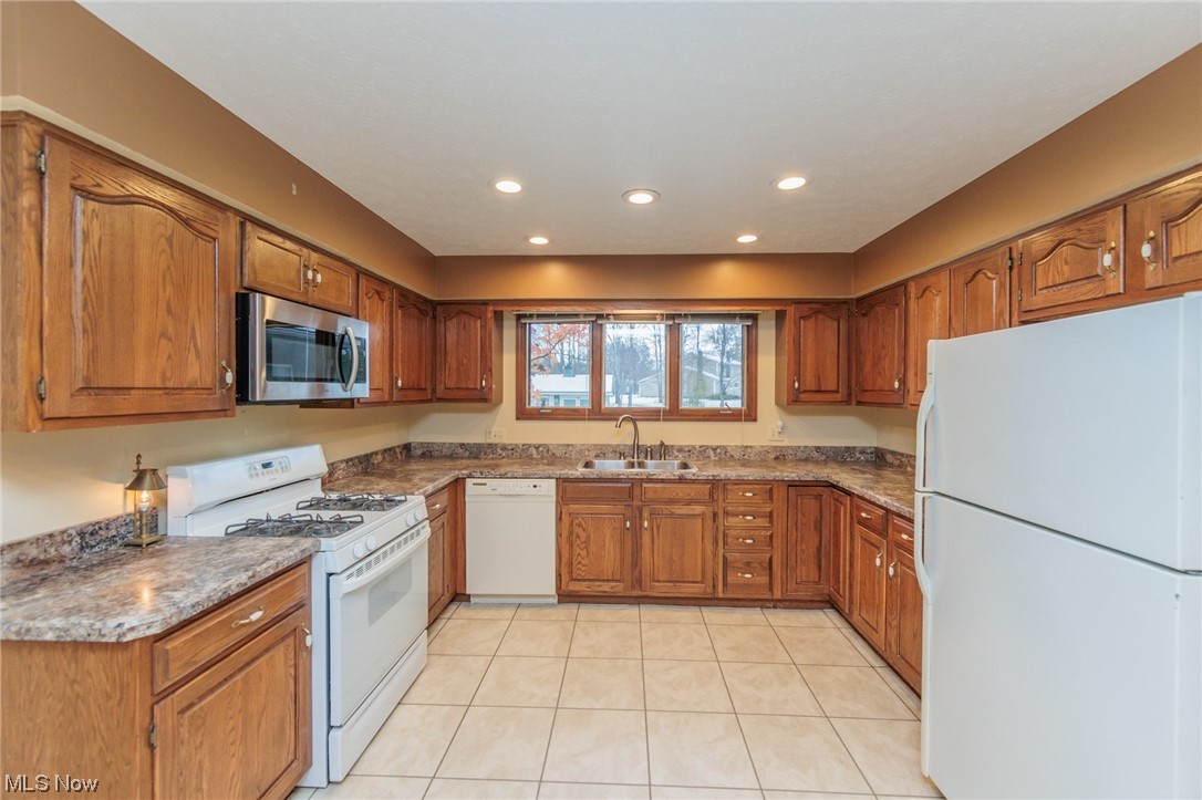 36085 Bainbridge Road Solon, OH 44139 - Photo 15 of 35 Kitchen with white appliances, sink, dark stone counters, and light tile floors