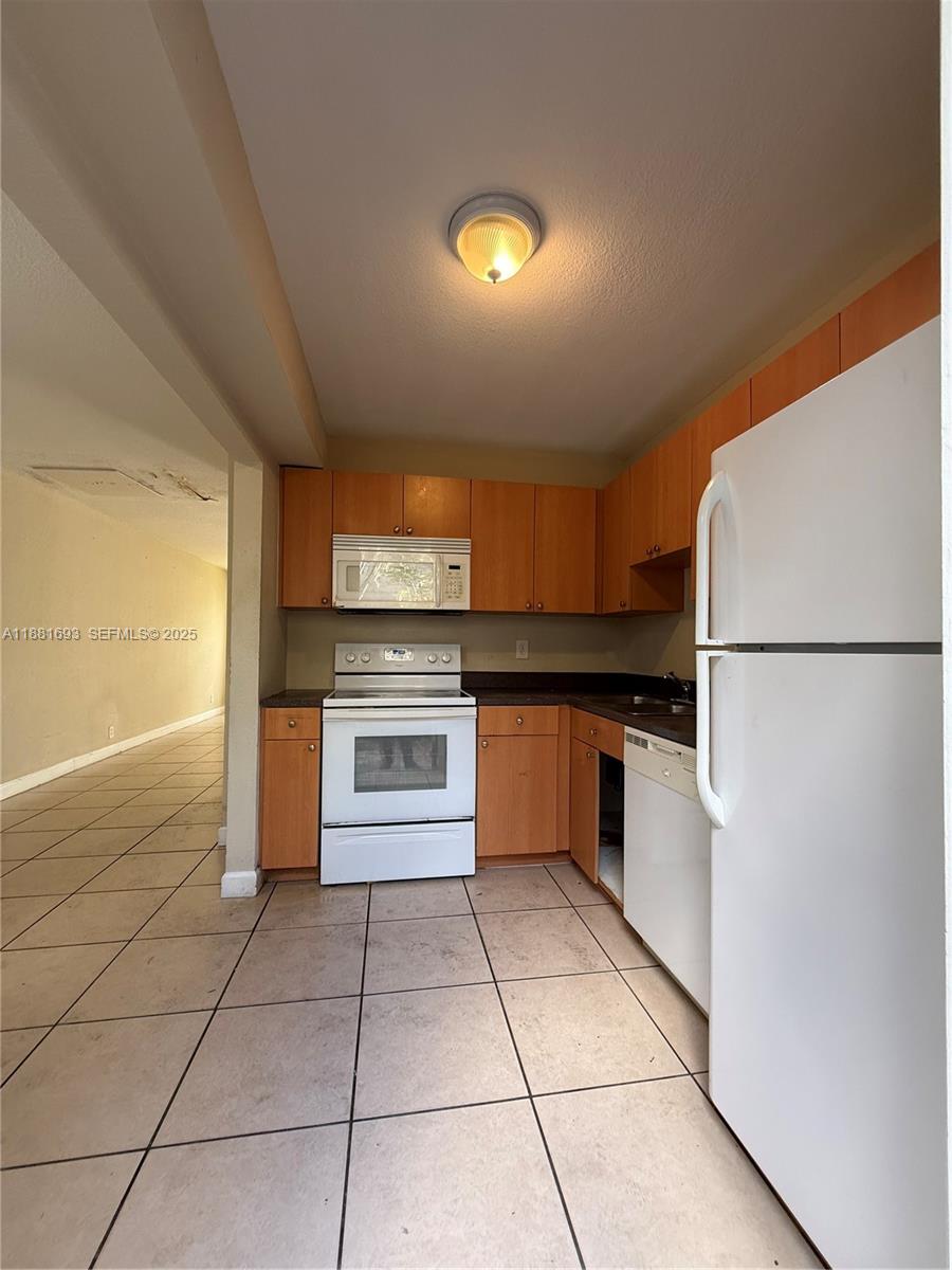 4625 Northwest 9th Drive, Unit 4625 Plantation, FL 33317 - Photo 11 of 26 a kitchen with a refrigerator and a cabinets