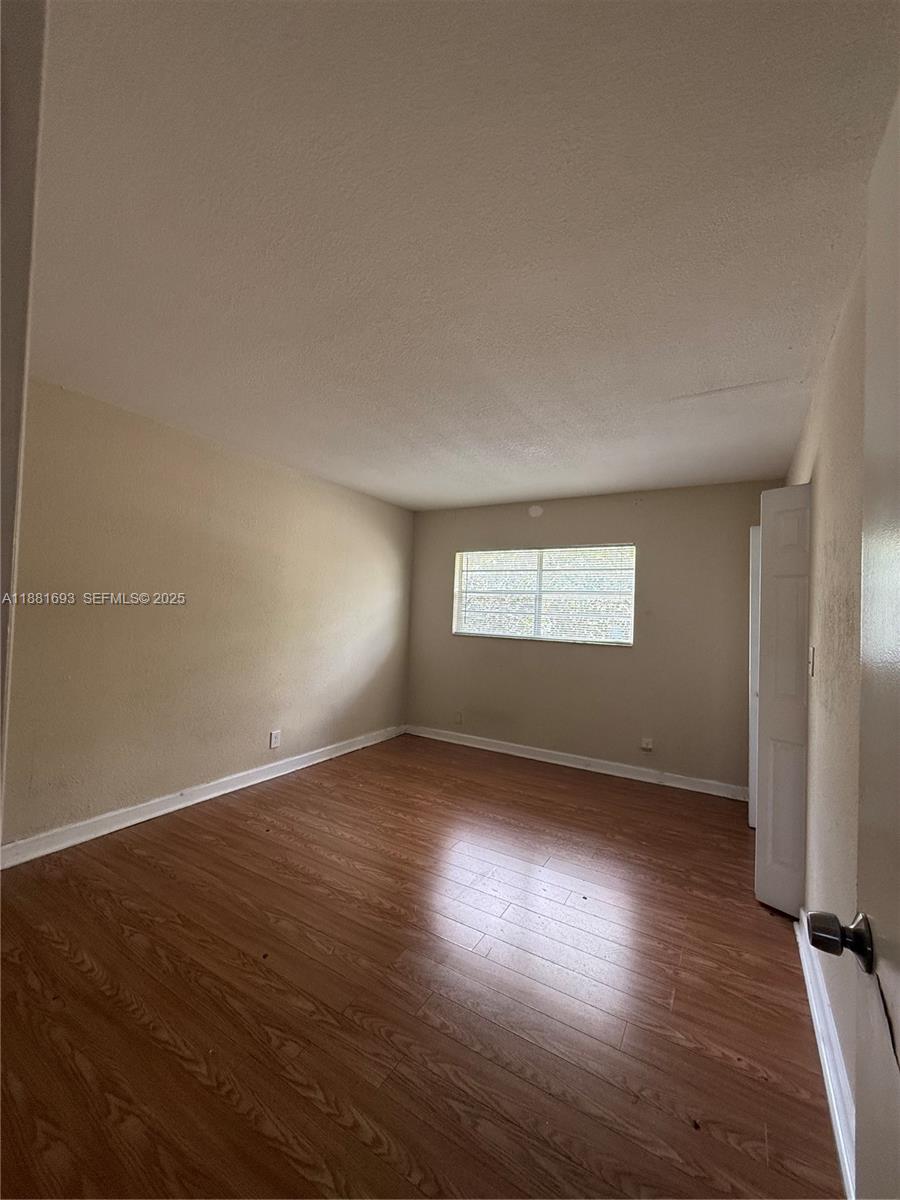 4625 Northwest 9th Drive, Unit 4625 Plantation, FL 33317 - Photo 18 of 26 an empty room with wooden floor and windows