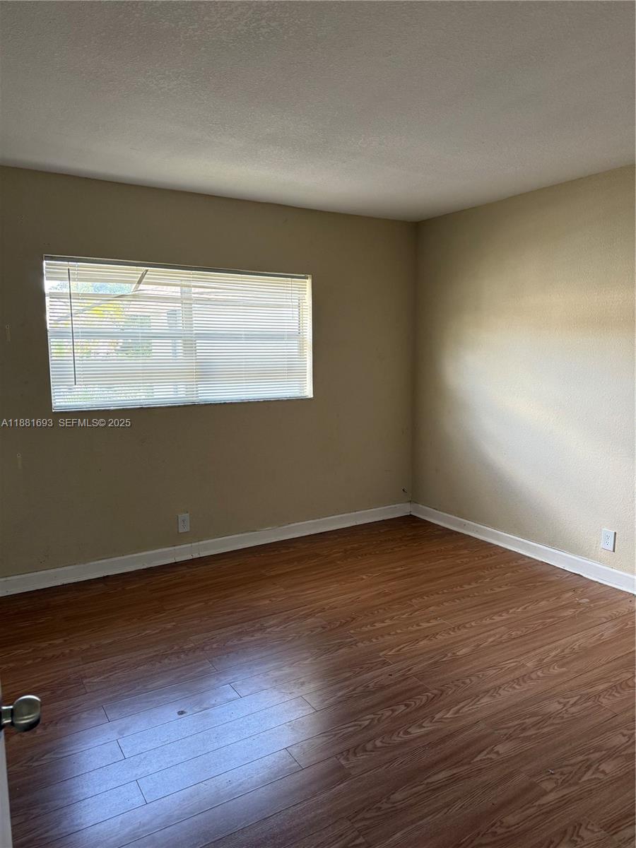 4625 Northwest 9th Drive, Unit 4625 Plantation, FL 33317 - Photo 21 of 26 a view of an empty room with wooden floor and a window