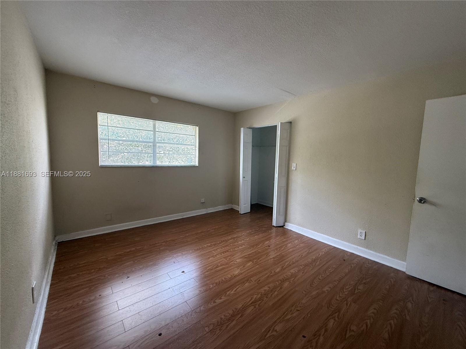 4625 Northwest 9th Drive, Unit 4625 Plantation, FL 33317 - Photo 23 of 26 an empty room with wooden floor and windows