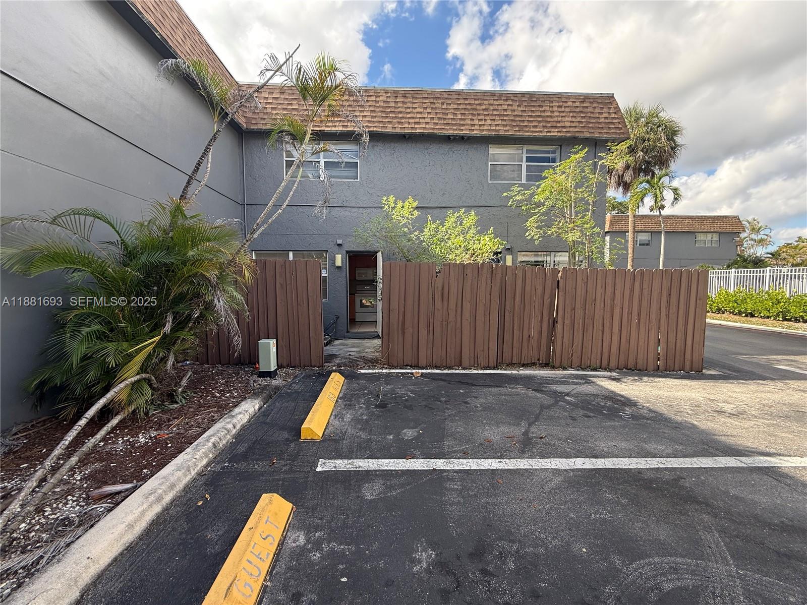 4625 Northwest 9th Drive, Unit 4625 Plantation, FL 33317 - Photo 26 of 26 a view of backyard with wheel chair potted plants and wooden fence