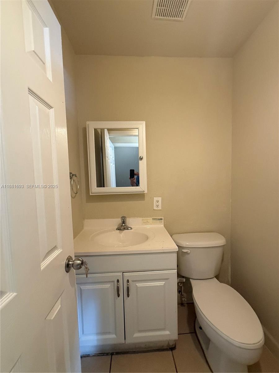 4625 Northwest 9th Drive, Unit 4625 Plantation, FL 33317 - Photo 4 of 26 a bathroom with a toilet a sink and mirror