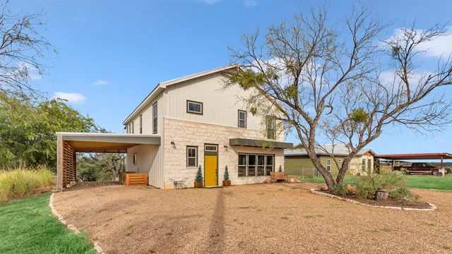 a front view of a house with a dirt yard and a garage