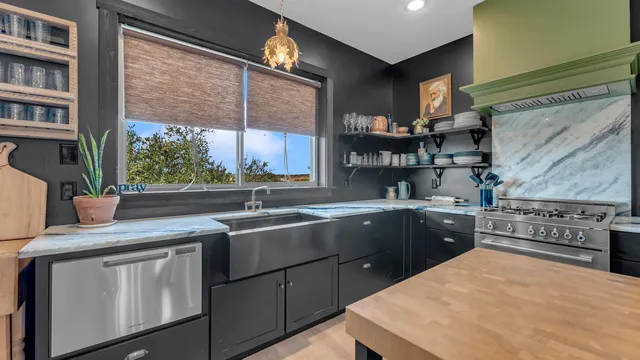 a kitchen with stainless steel appliances granite countertop a sink and a stove