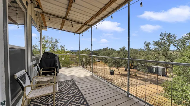a view of a patio with table and chairs with wooden floor and fence