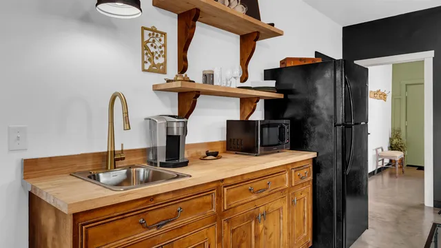 a living room with stainless steel appliances furniture and a table