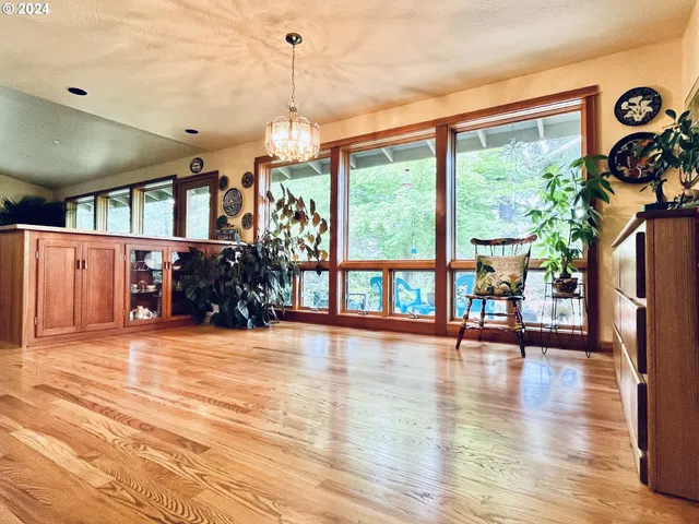 a view of empty room with wooden floor and windows