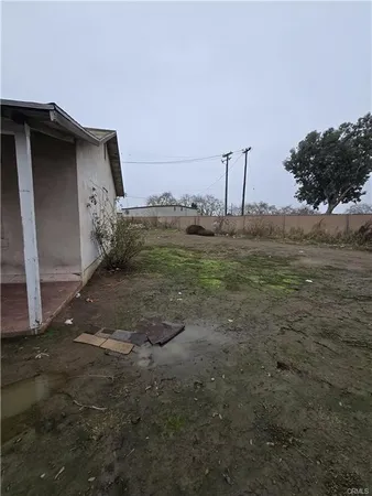 a view of a dry yard with wooden fence