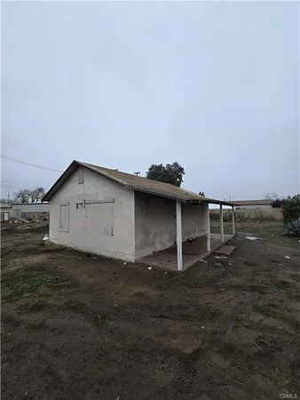a backyard of a house with table and chairs