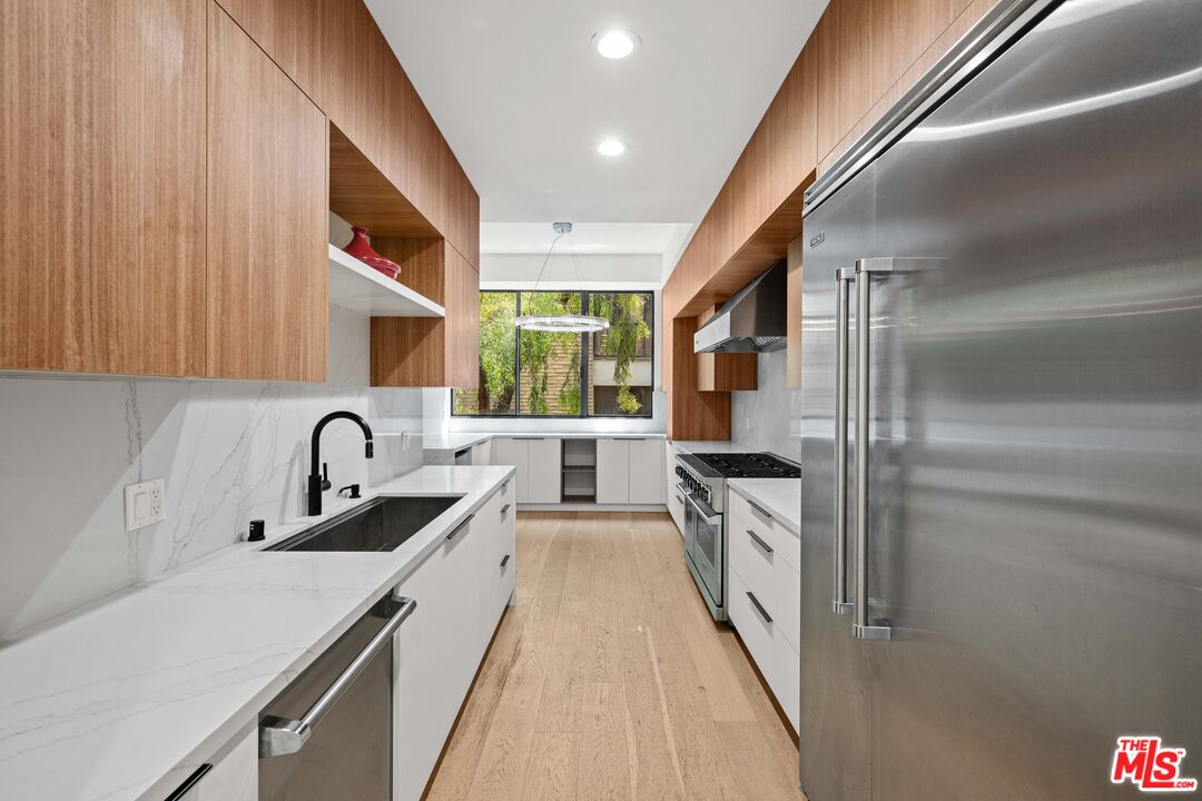 a kitchen with stainless steel appliances granite countertop a sink and stove