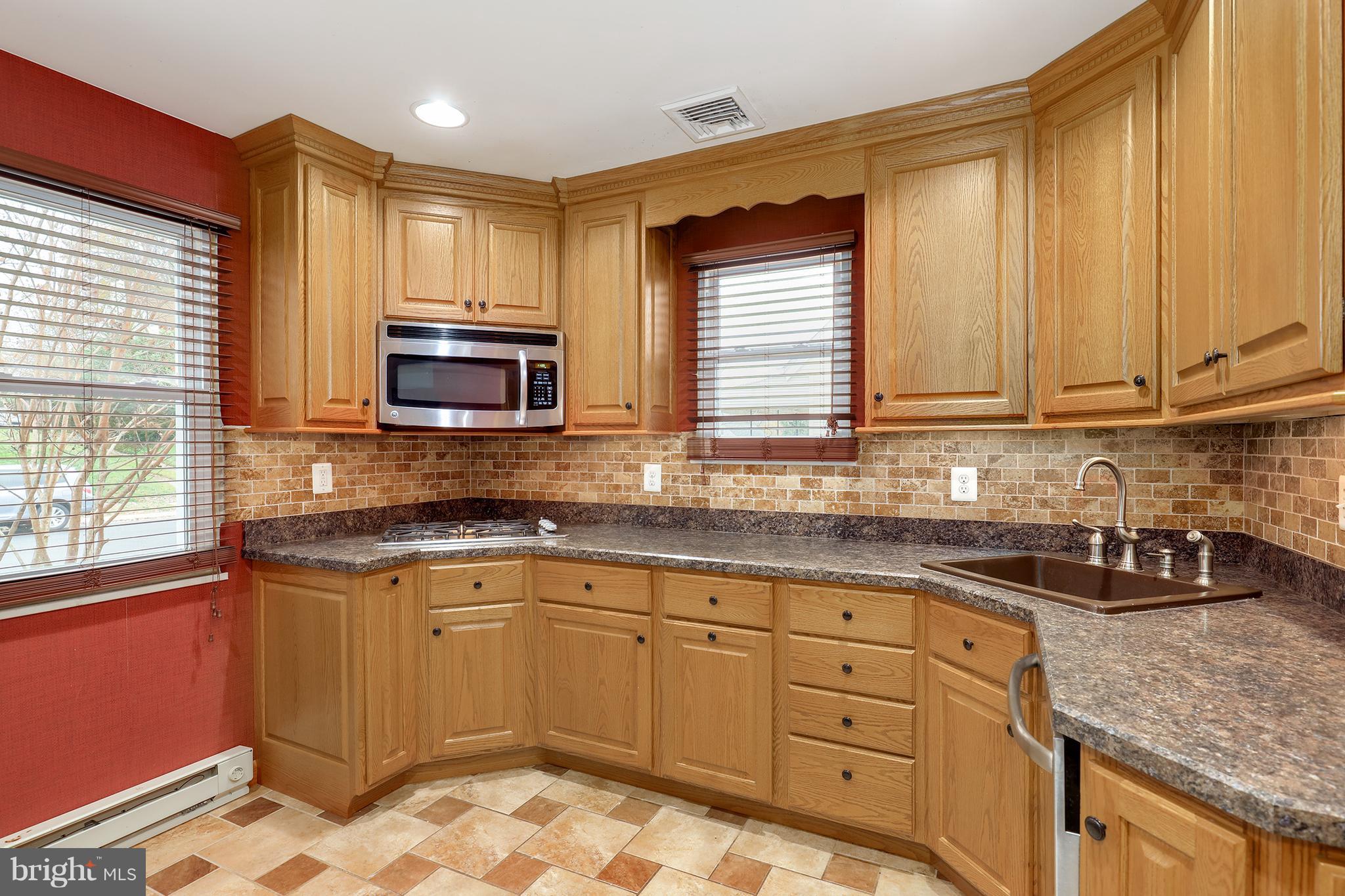 5545 Gayland Road Baltimore, MD 21227 - Photo 7 of 30 a kitchen with stainless steel appliances granite countertop a sink stove and microwave