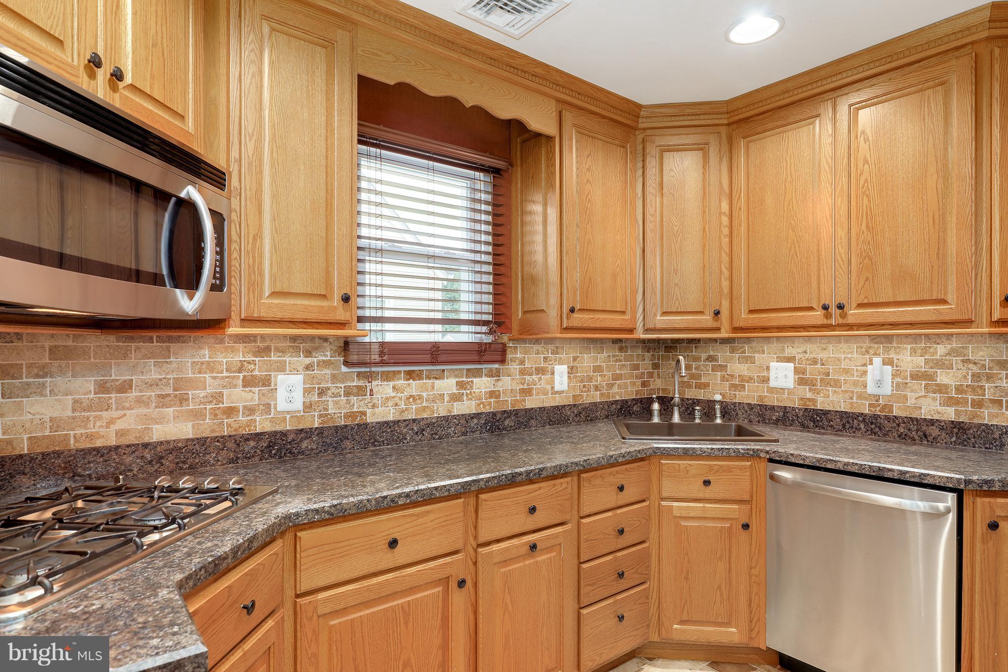 5545 Gayland Road Baltimore, MD 21227 - Photo 8 of 30 a kitchen with granite countertop cabinets stainless steel appliances a sink and a window