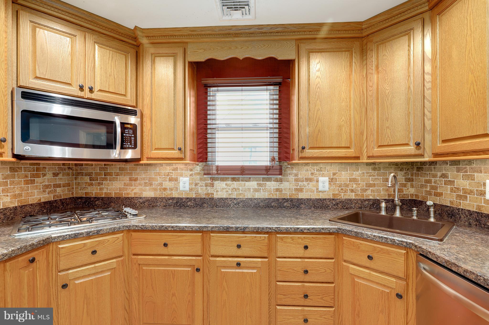 5545 Gayland Road Baltimore, MD 21227 - Photo 10 of 30 a kitchen with granite countertop cabinets stainless steel appliances a sink and a window