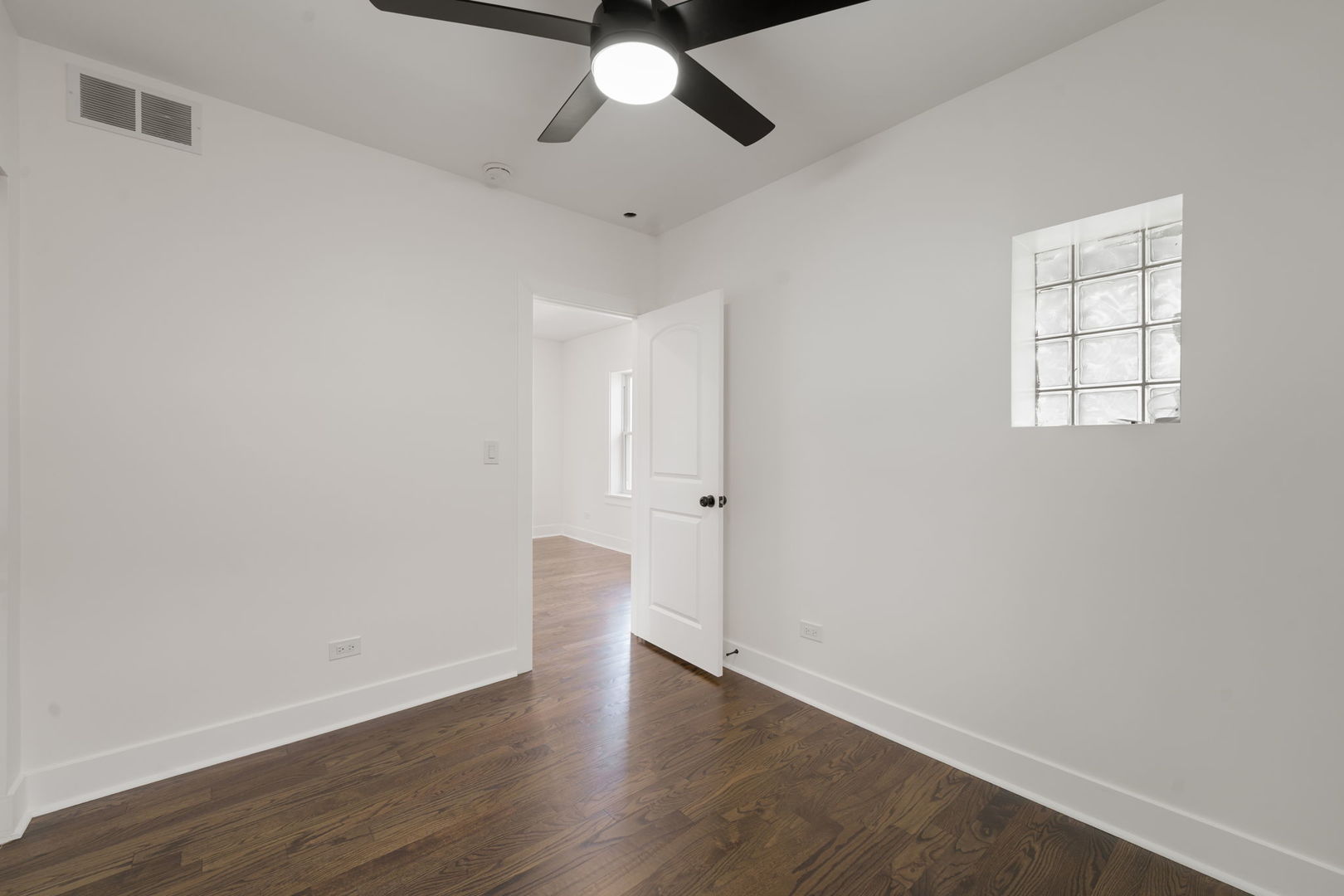 2733 Wesley Avenue Berwyn, IL 60402 - Photo 17 of 33 an empty room with wooden floor ceiling fan and window