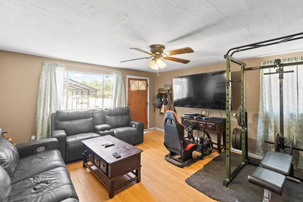 a living room with furniture a flat screen tv and a window