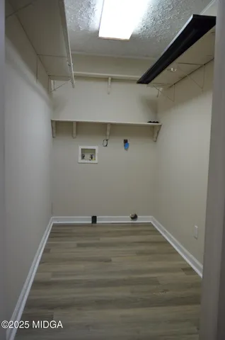 an empty room with a chandelier fan and windows