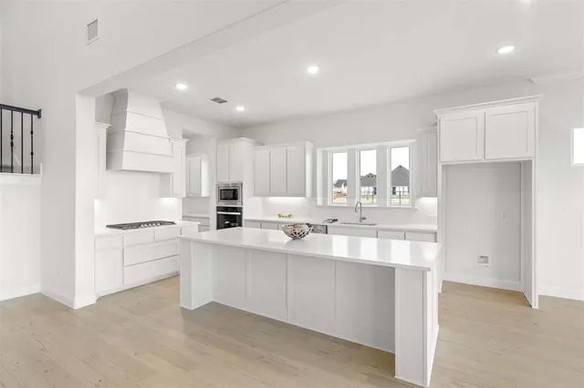 a kitchen with white cabinets sink and stainless steel appliances