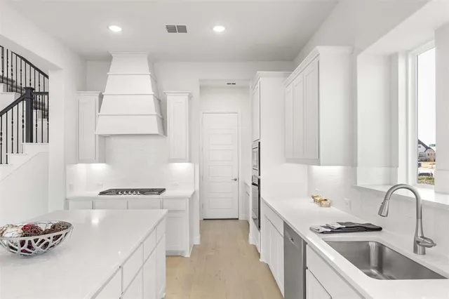 a kitchen with stainless steel appliances a sink a stove and a refrigerator