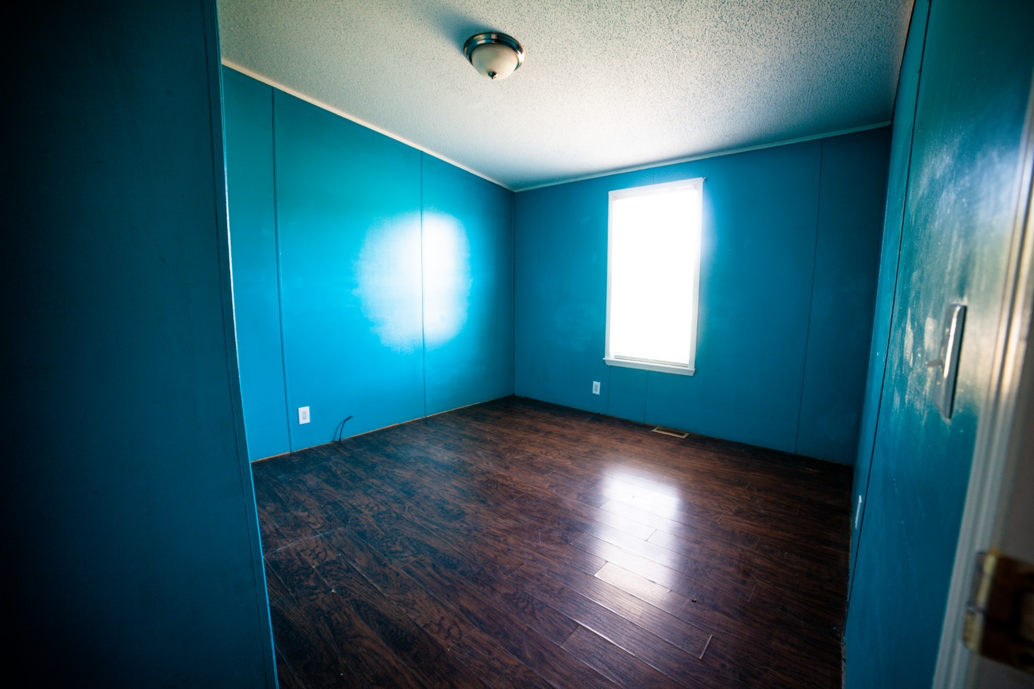 1606 Harpo Road Manchester, TN 37355 - Photo 12 of 27 an empty room with wooden floor and windows