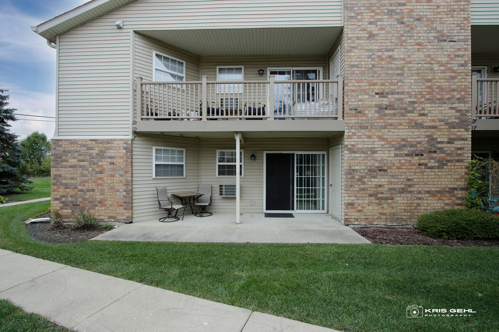 1551 Crystal Rock Court, Unit 1D Round Lake Beach, IL 60073 - Photo 14 of 16 a view of brick house with a large window and a yard