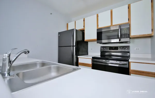 a kitchen with a refrigerator a stove and a sink
