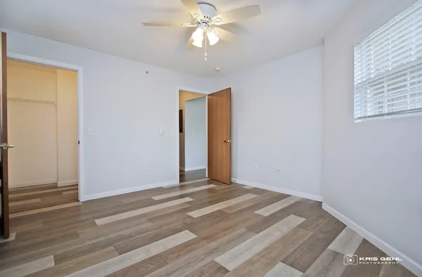a view of a room with wooden floor and a ceiling fan