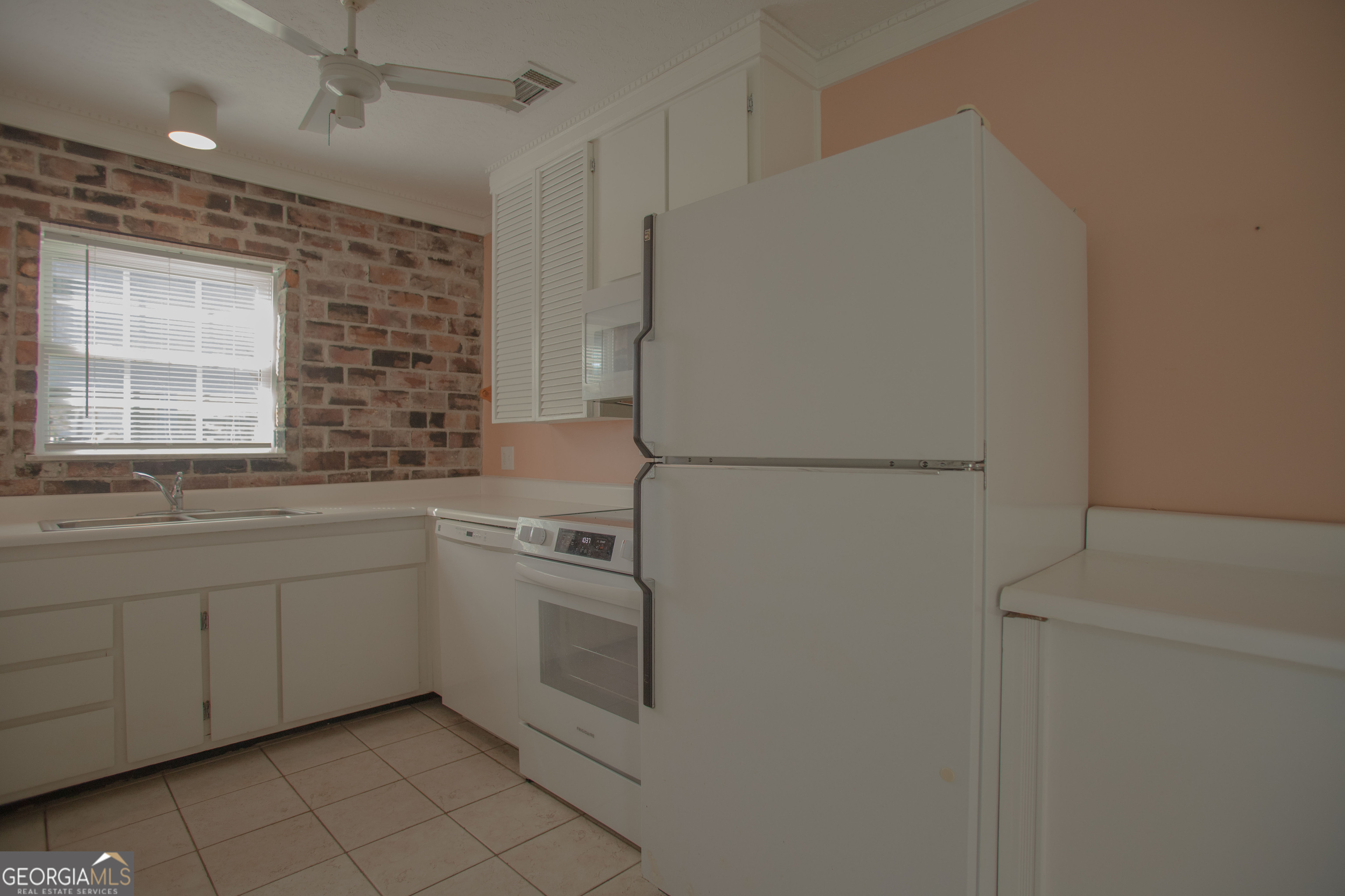 743 Cattle Hammock Road Midway, GA 31320 - Photo 22 of 63 a kitchen with white cabinets and white appliances