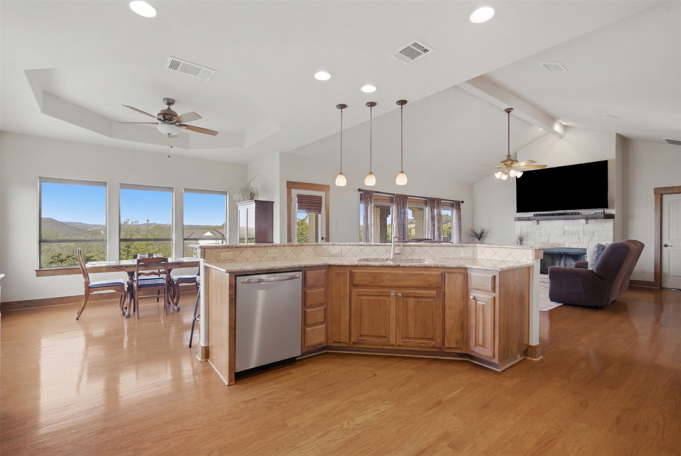 700 Augusta Circle Point Venture, TX 78645 - Photo 34 of 35 An open floor plan with hardwood floors flows seamlessly from kitchen to dining area and living space, offering picturesque views.