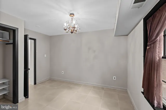 an empty room with chandelier fan