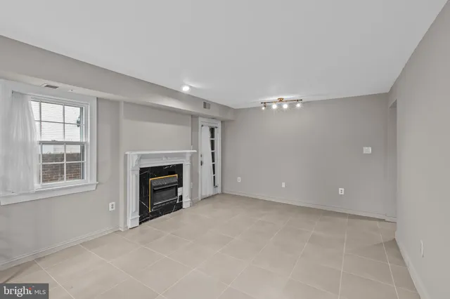 a view of an empty room with a fireplace and a window