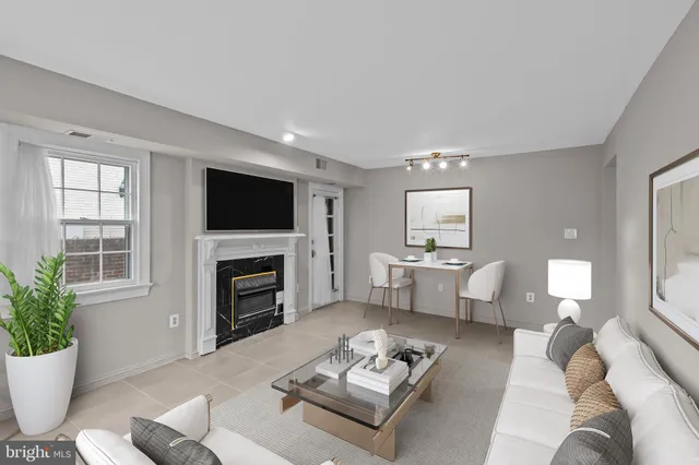 a living room with furniture a fireplace and a flat screen tv