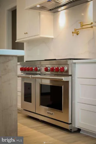 a stove top oven sitting inside of a kitchen