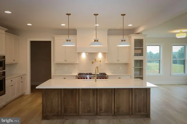 a kitchen with kitchen island a sink stainless steel appliances and cabinets